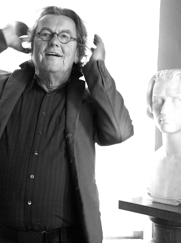 Lutz G&ouml;rner im Anzug steht neben einer B&uuml;ste auf einem Sockel, Beide in einem hellen Raum.